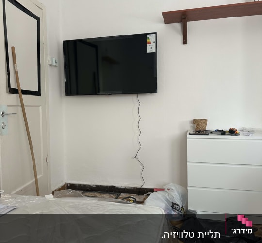 חדר עם טלוויזיה תלויה, כלי עבודה על שידה